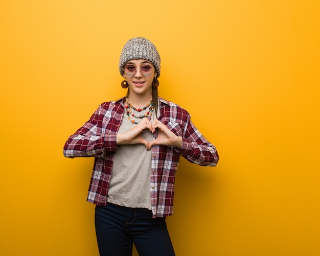 Donna naturale del giovane hippie che fa una forma del cuore con le mani