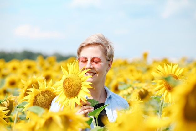 Donna nel campo di girasoli Estate Giovane bella donna in piedi nel campo di girasoli