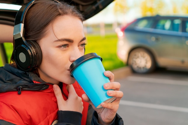 Donna nel concetto di autunno auto Sorridente bella ragazza che ascolta la musica