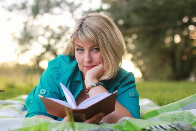 Donna nel parco con libro sull'erba