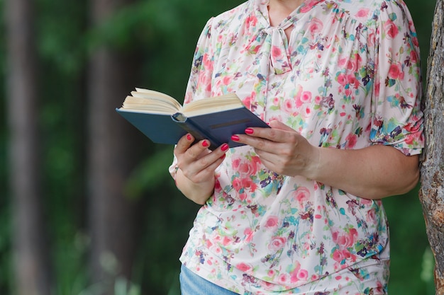 Donna nel parco di estate che legge un libro