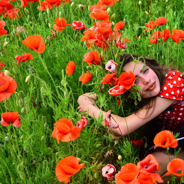 Donna nel raccolto del campo di fiori di papavero