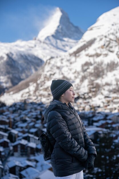 Donna nel villaggio di Zermatt con la montagna del Cervino al mattino Zermatt Svizzera