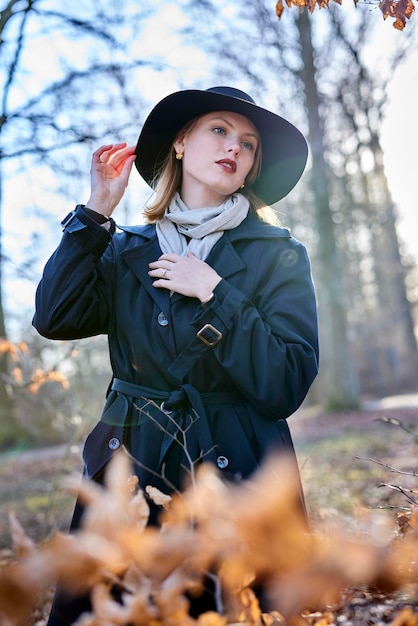 Donna nella foresta con cappello e sole