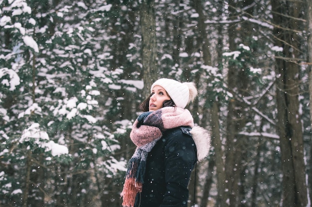 Donna nella foresta durante la nevicata