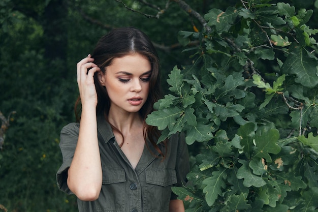 Donna nella foresta Foglie verdi di un cespuglio primo piano aria fresca natura