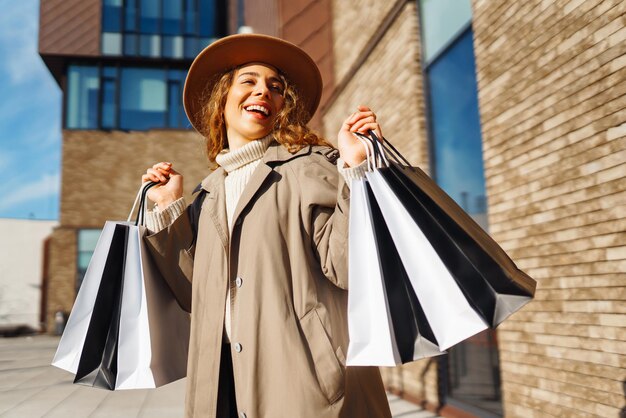 Donna nello shopping Ragazza giovane con borse della spesa colorate che passeggia per la città dopo lo shopping