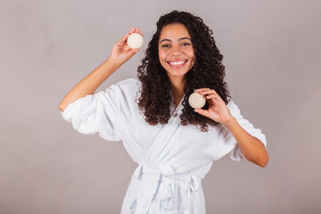 Donna nera brasiliana che indossa accappatoio e asciugamano prodotti vegani per la bellezza e saponi per la cura della pelle e dei capelli Spa benessere benessere