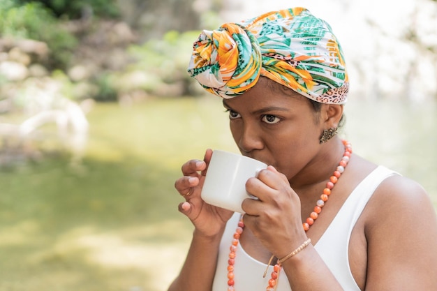 Donna nera che gode del caffè del mattino in riva al fiume