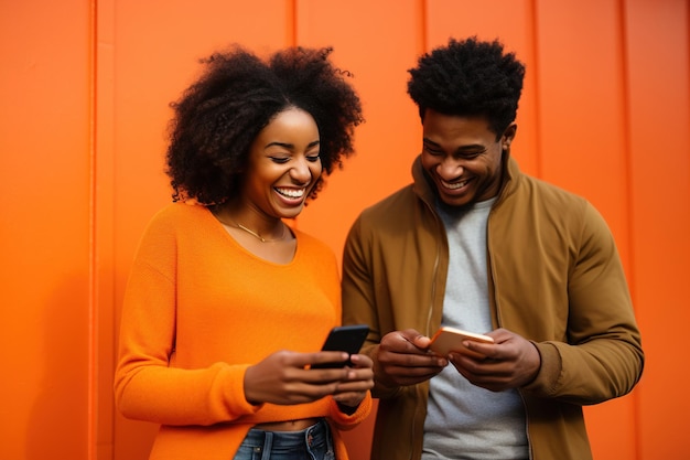 donna nera e uomo nero con il telefono su sfondo arancione