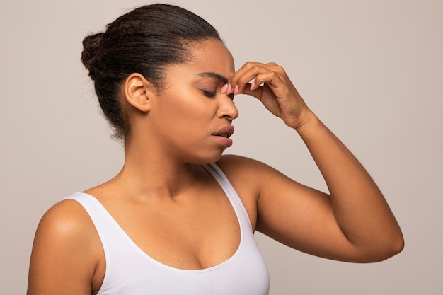 Donna nera stanca che tocca il ponte del naso ha l'emicrania copia spazio