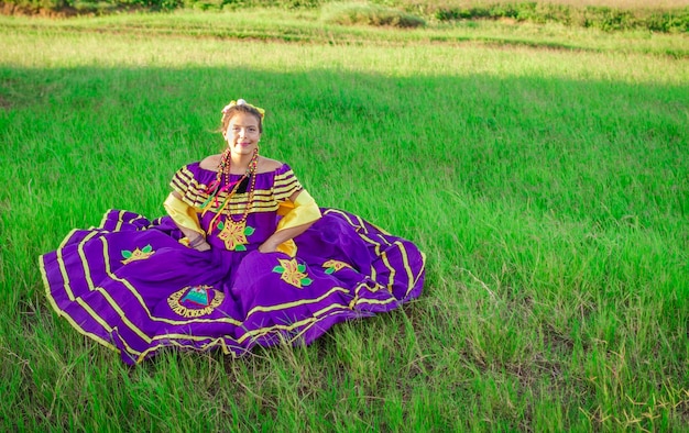 Donna nicaraguense che indossa abiti tradizionali seduti sull'erba Donna in abiti popolari del Nicaragua seduta sull'erba nel campo