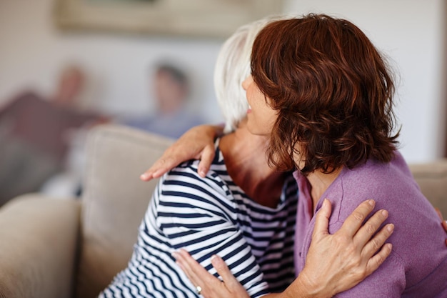 Donna nonna e abbraccio sul divano di casa con cura della famiglia e genitore amore o sorriso Felicità pensionamento e adulto con mamma anziana insieme o riunione ciao e abbraccio e soggiorno