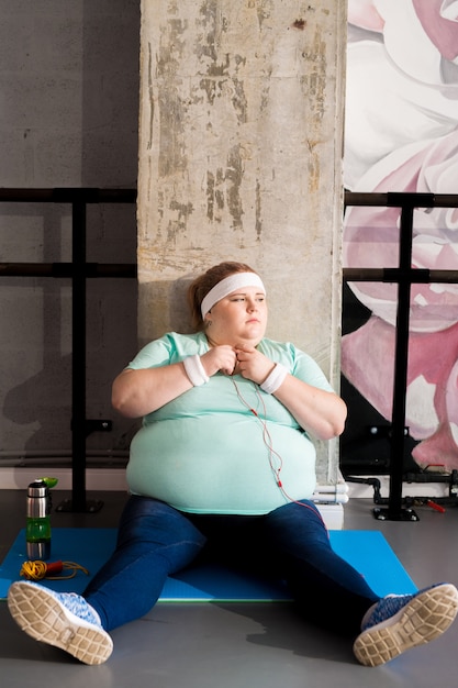 Donna obesa che si rilassa nel fitness club