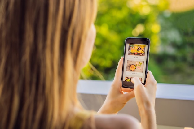 Donna ordina cibo per il pranzo online usando uno smartphone