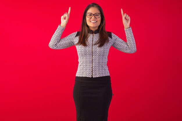 Donna orientale adulta che indossa abbigliamento formale in studio fotografico con sfondo blu.