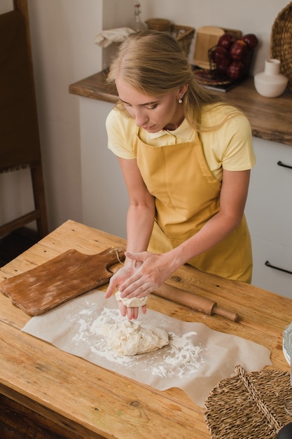 Donna pasticcere o panettiere o casalinga impasta la pasta in cucina. Pubblicità di prodotti da forno fatti in casa