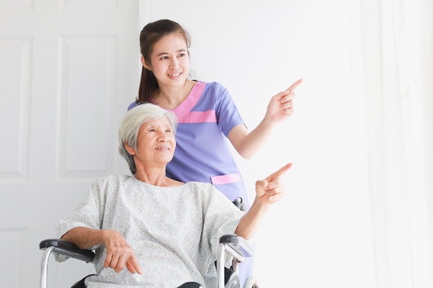 Donna paziente anziana asiatica che parla con le donne di medico nell'ospedale dell'ufficio della clinica