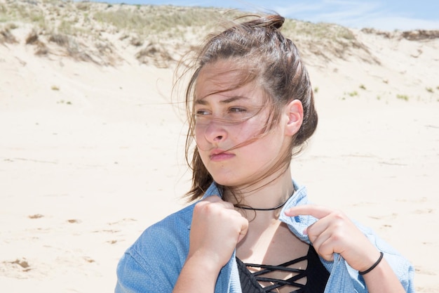 Donna pensierosa seduta sulle dune a guardare il mare