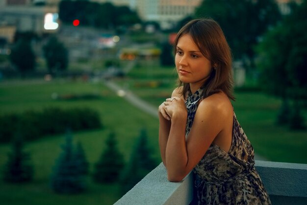 Donna pensierosa sul balcone al tramonto