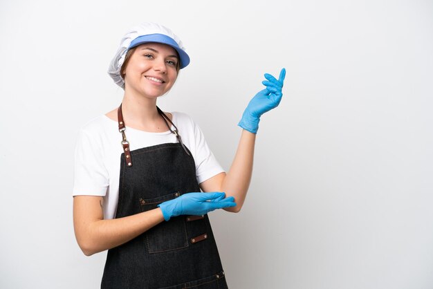 Donna pescivendolo che indossa un grembiule allungando le mani di lato per invitare a venire