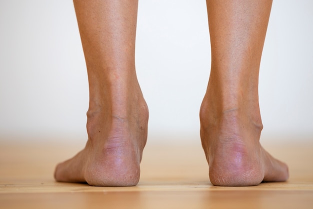 Donna piedi nudi sul pavimento. Cura delle gambe e concetto di trattamento della pelle.