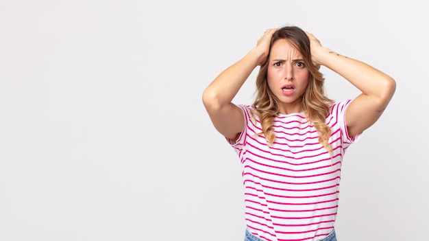 Donna piuttosto magra che si sente stressata, preoccupata, ansiosa o spaventata, con le mani sulla testa, in preda al panico per l'errore