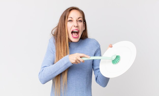 donna piuttosto magra con in mano un piatto pulito e vuoto