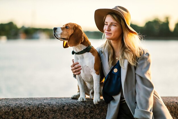 Donna positiva che abbraccia il cane Beagle sul lungomare