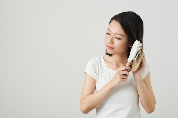 Donna positiva che gode di spazzolatura dei capelli