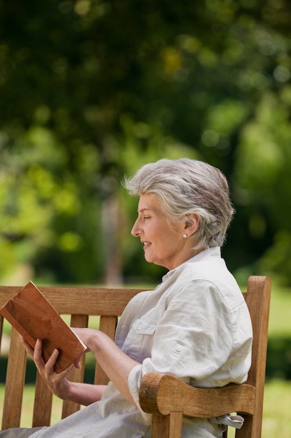 Donna reired leggendo un libro in panchina