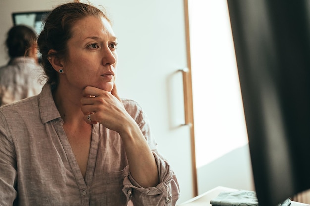 Donna riflessiva sullo schermo del computer