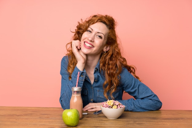 Donna rossa felice facendo colazione