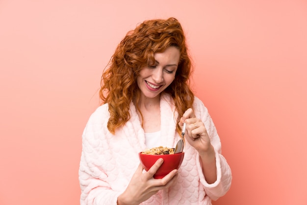 Donna rossa in vestaglia in possesso di una ciotola di cereali