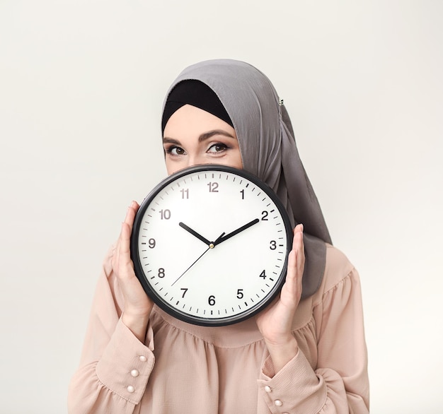 Donna saudita in hijab con orologio su sfondo bianco