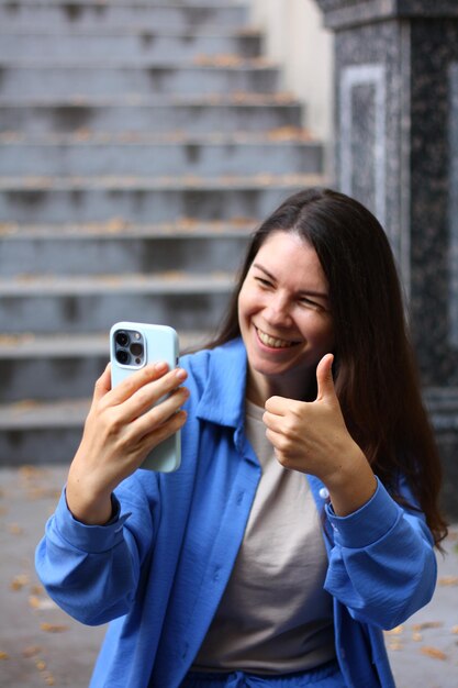donna scatta una foto sul telefono un segno cool selfie