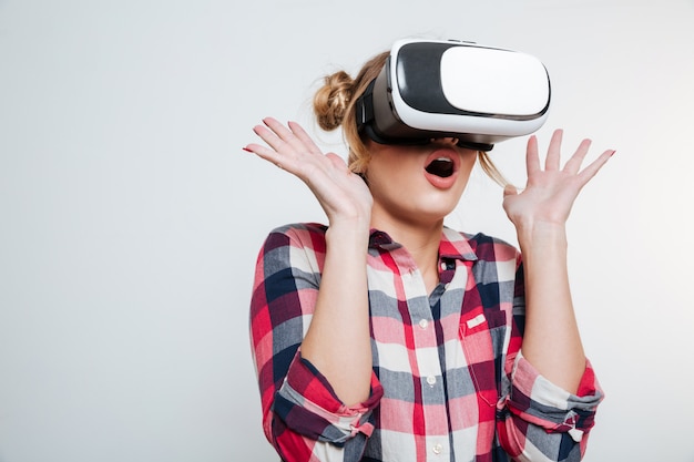 Donna scossa in camicia usando il dispositivo di realtà virtuale