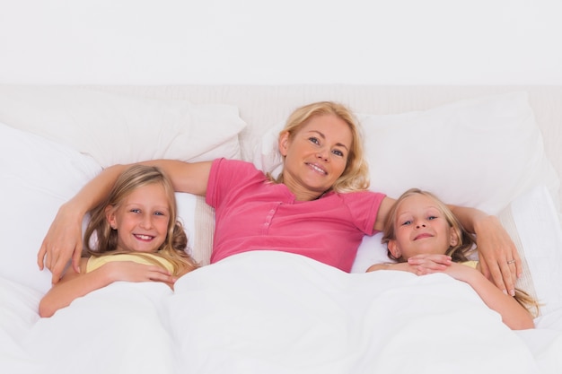 Donna sdraiata a letto con i suoi figli