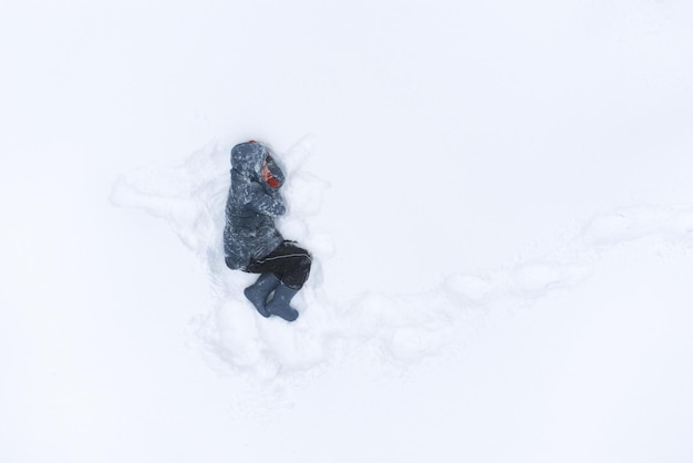 Donna sdraiata che riposa nella neve Vista aerea