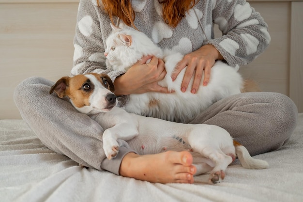 Donna seduta a gambe incrociate con gli animali domestici a casa