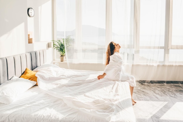 Donna seduta a letto al mattino