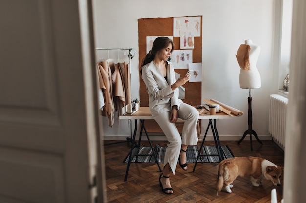 Donna seduta a tavola che scatta foto al suo cane