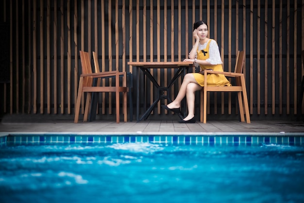 Donna seduta accanto alla piscina