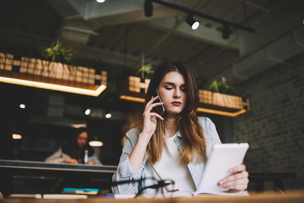 donna seduta al bar e parlando con un amico su smartphone ragazza che tiene il telefono cellulare