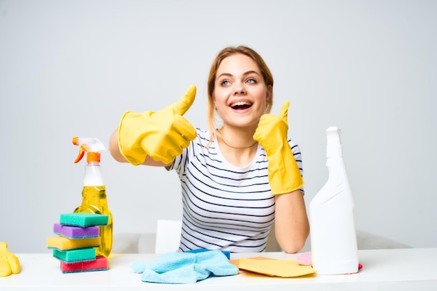 Donna seduta al tavolo guanti di gomma pulizia servizio detergente lavori domestici