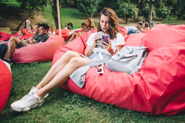 Donna seduta all'aperto a bere un cocktail nel parco pubblico