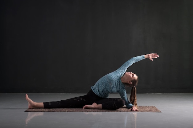 Donna seduta in posa yoga Parivrtta Janu Sirsasana