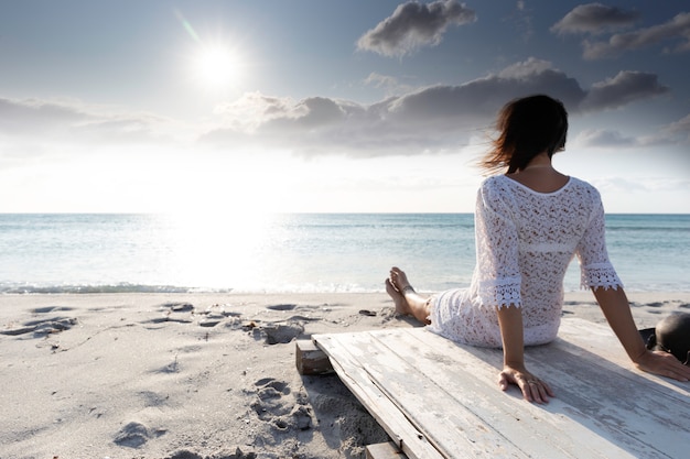 donna seduta in riva al mare guardando l'orizzonte