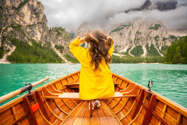 Donna seduta in una grande barca marrone al lago Braies in un giorno nuvoloso in Italia vacanze estive in Europa