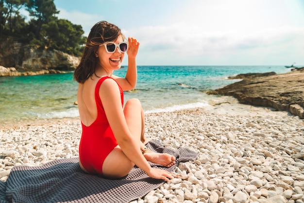 Donna seduta su una coperta in spiaggia del mare